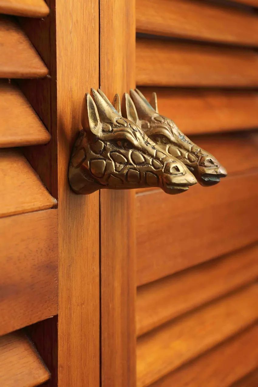 Cast brass animal-head handle on a wooden louvre door