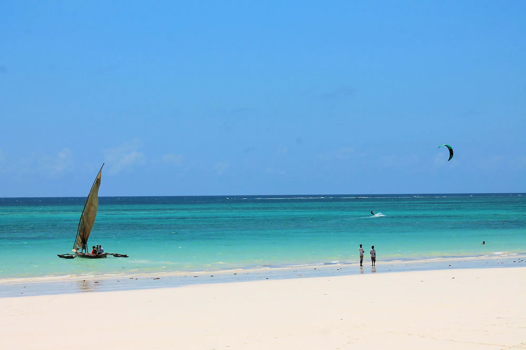 Diani Beach with a sailboat and a kite over the water