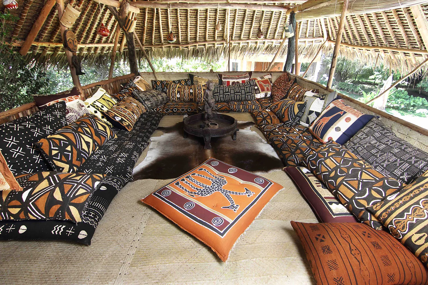 The upstairs chill deck, printed cushions under a makuti roof