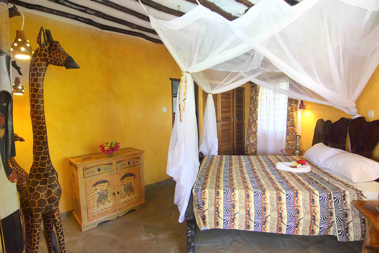 Bedroom with a yellow wall and a framed giraffe